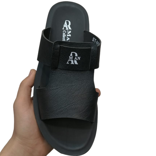 Black slipper held in a hand with visible branding on a white background front view