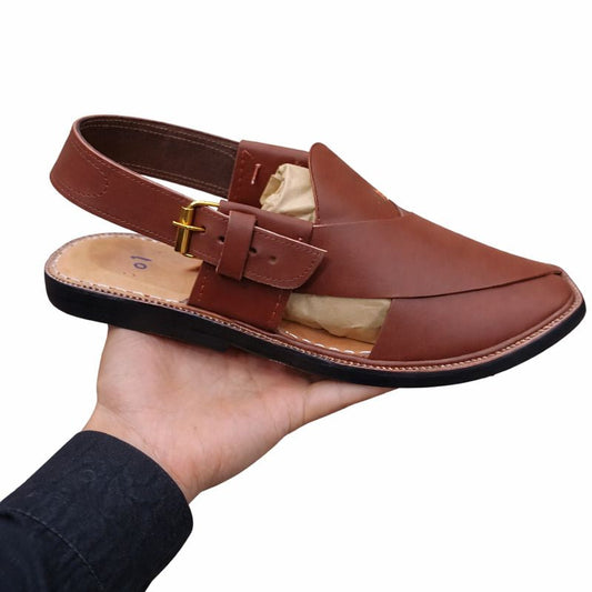 Brown peshawari sandal right side view held in a hand against a white background