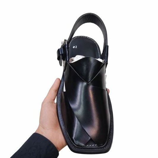 Peshawari Black sandal held by a hand on a white background