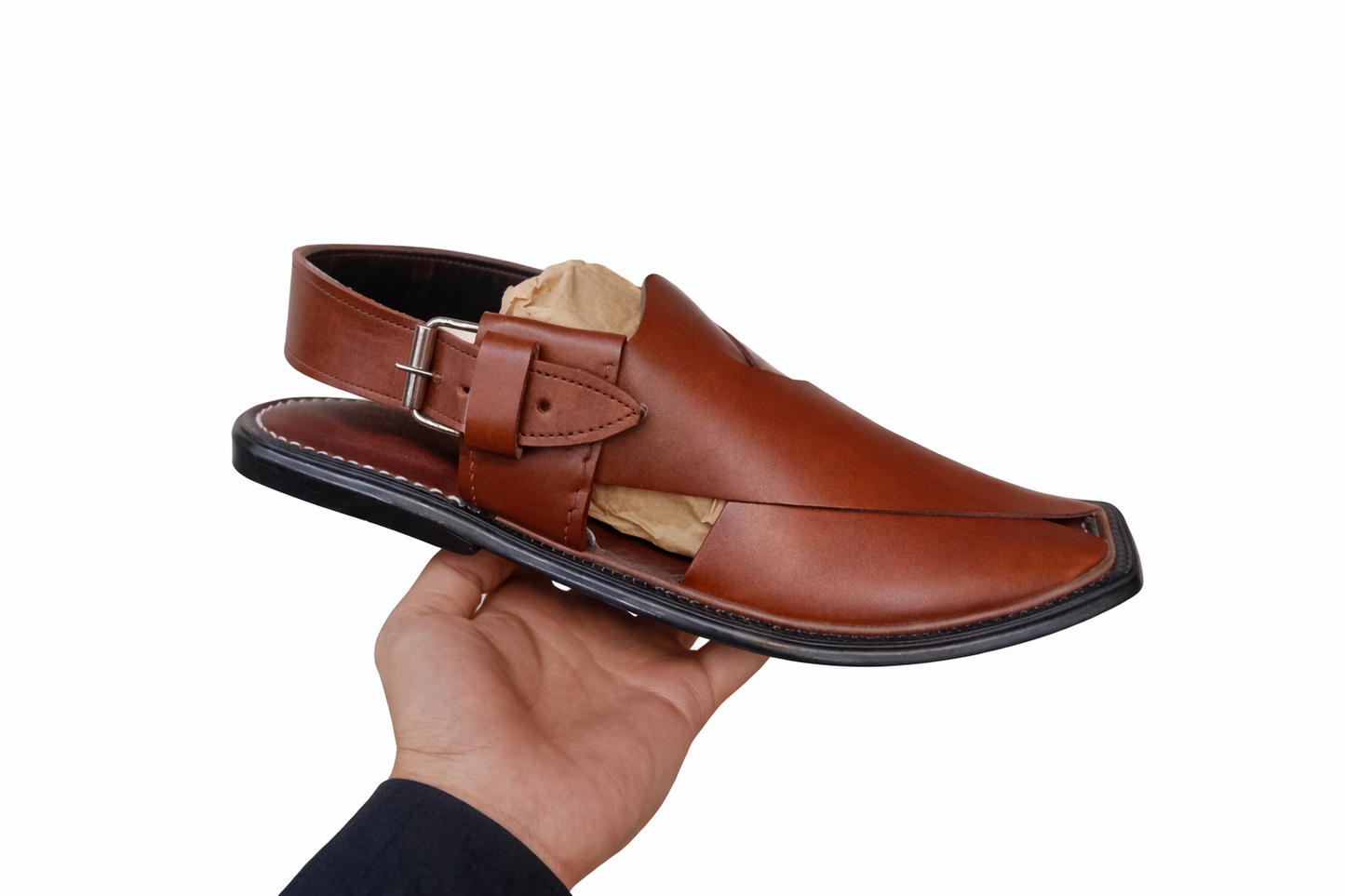 Peshawari Brown sandal with a strap held by a hand on a white background